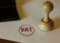 VAT stamp and stamping hand. Value-added tax and invoice payment concept.