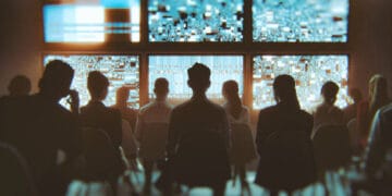 Group of people watching multiple TV sets at the same time. This is entirely 3D generated image.