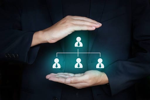 Business man holding team member icon on hands; Teamwork and organization concept